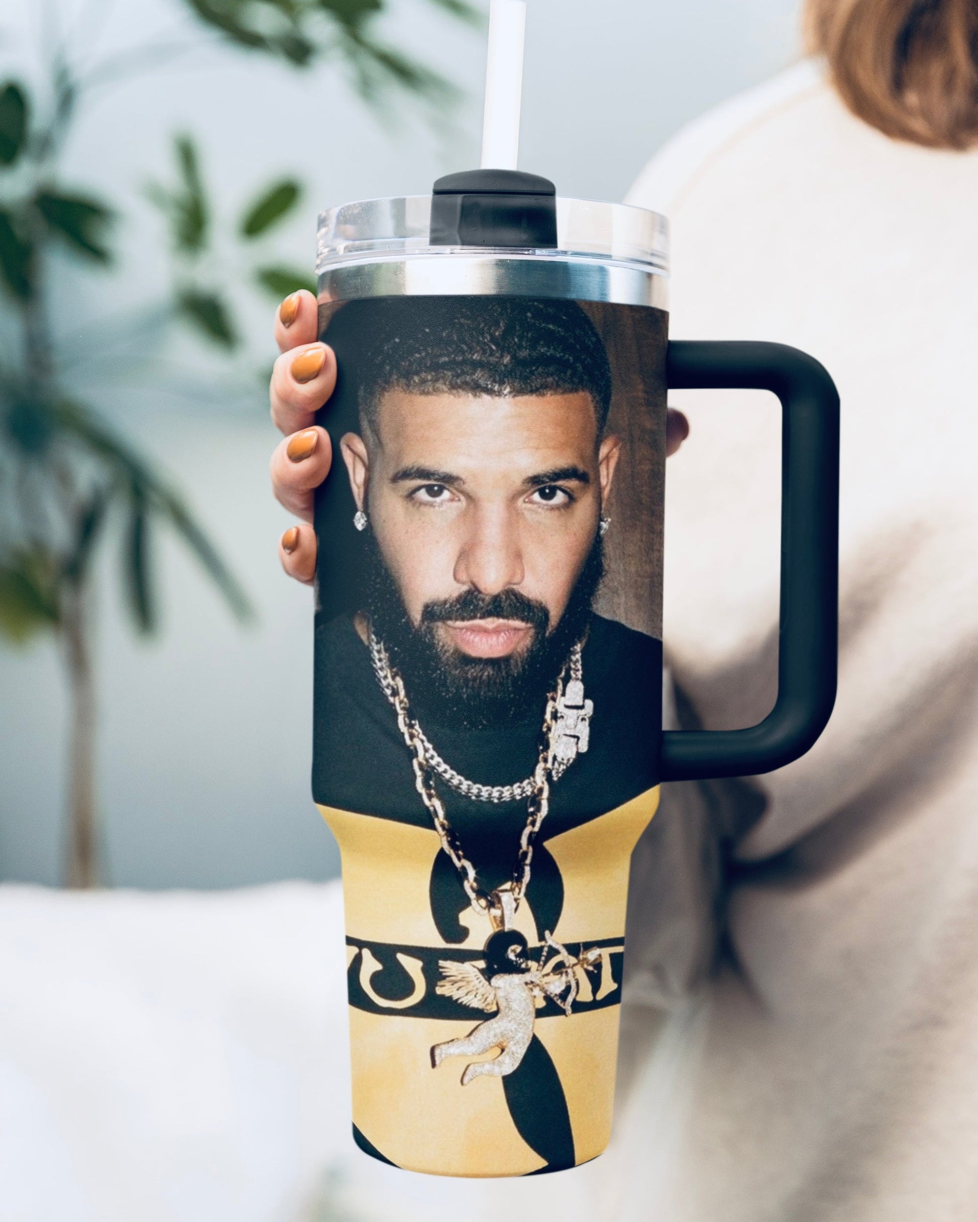 Person holding a tumbler with a graphic design of a well-known figure.