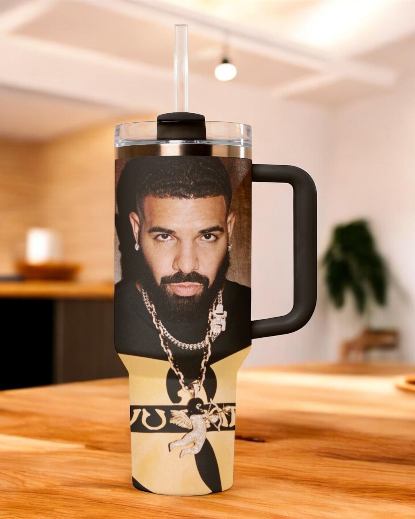Travel mug with a Drake face printed on it, placed on a wooden surface. 